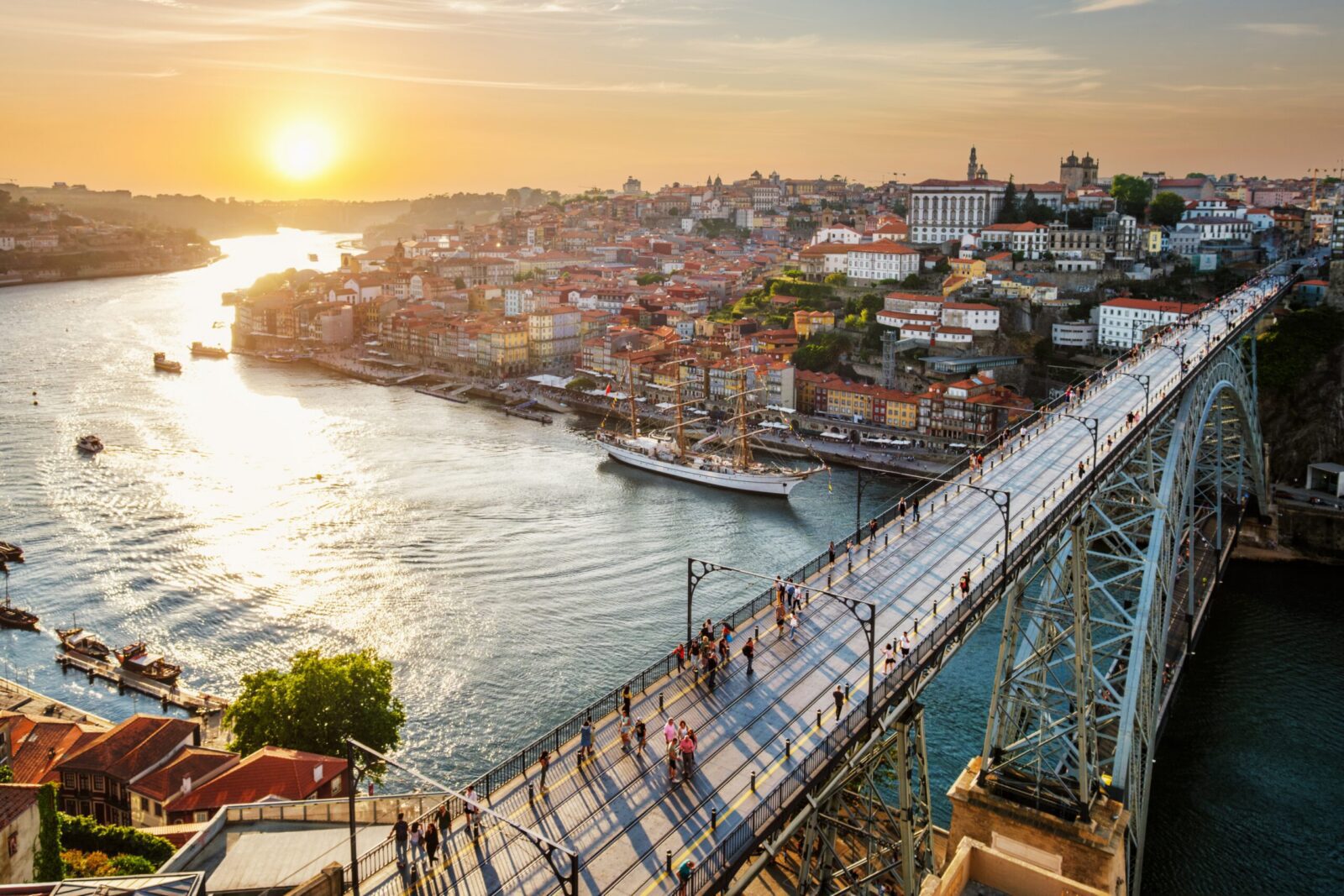 Porto city skyline with riverfront and Dom Luís I Bridge at sunset, representing moving to Portugal from UK, Porto lifestyle, UK expats and affordable city living.