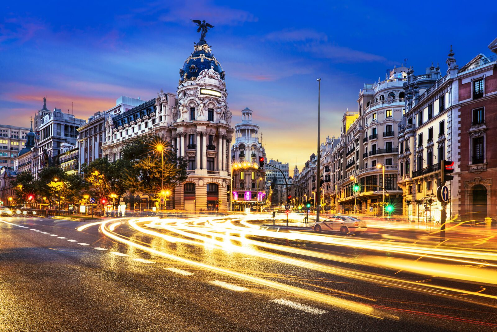 Madrid city centre at night with Gran Via traffic lights, representing best cities to live in Spain, urban lifestyle and expat opportunities for UK nationals moving to Spain from UK.