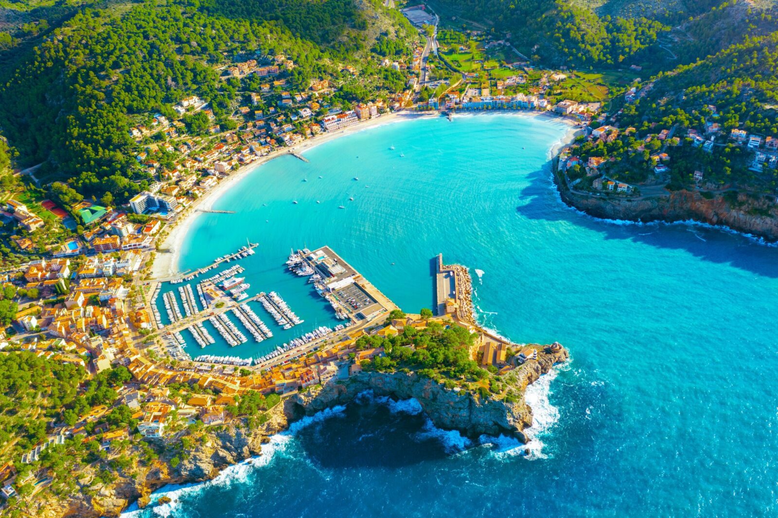 Aerial view of Mallorca coastline with turquoise sea and marina, representing best places to live in Spain, island lifestyle and property investment opportunities for UK expats moving to Spain from UK.