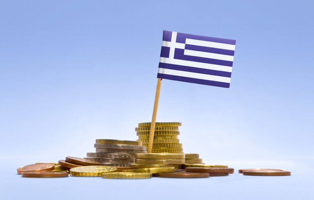 Greek flag on stacked coins representing wealth management in Greece for UK expats moving to Greece from UK and managing investments and pensions.