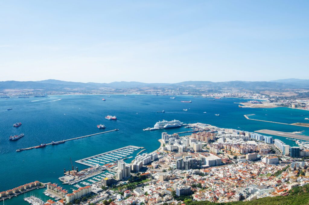 Move to Gibraltar aerial view of marina, coastline and residential property, representing moving to Gibraltar from UK, Gibraltar residency, property in Gibraltar and expat relocation planning.