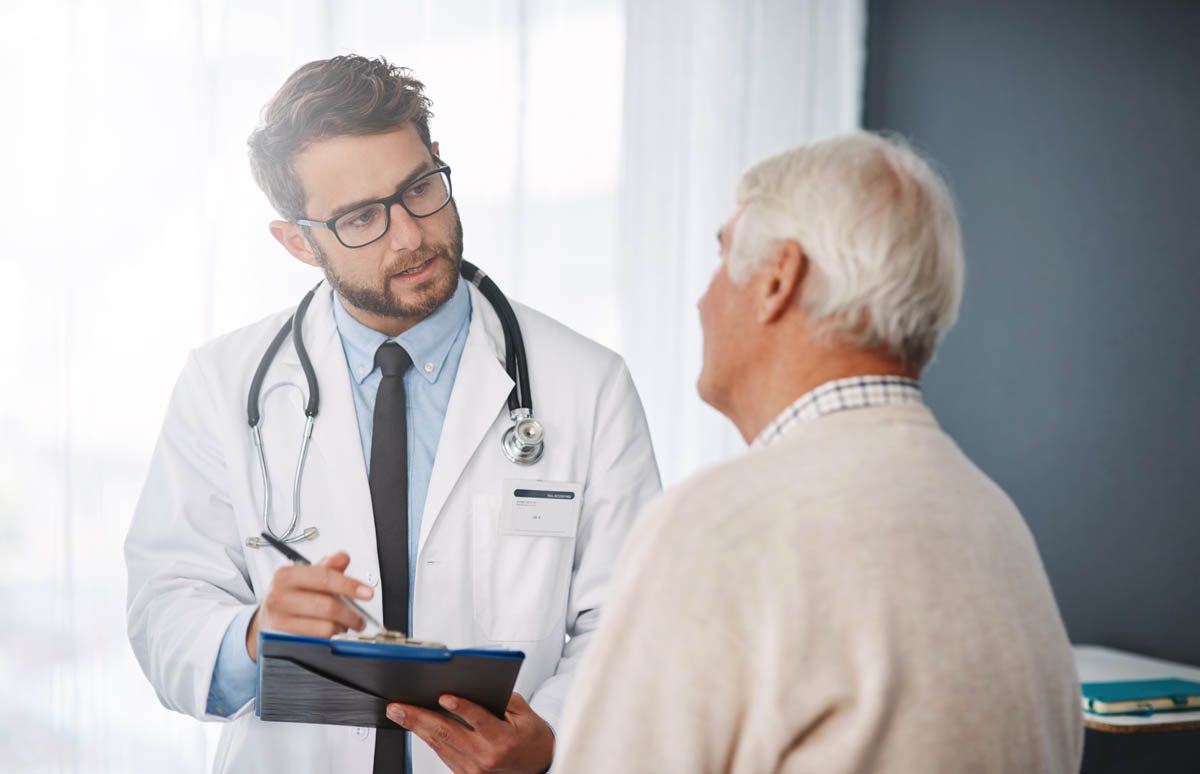 Doctor discussing healthcare with an older patient during a medical consultation.